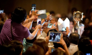 Feligreses capturando momentos con sus teléfonos móviles, un reflejo de la influencia digital en el primer Jubileo para influencers católicos